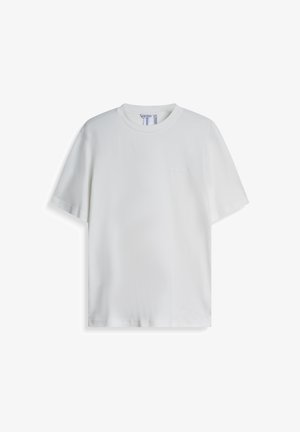 Bijela pamučna majica, kratki rukavi, okrugli izrez, s diskretnim logom na prsima, glatke teksture, regularnog kroja. Nema uzoraka ili naglasaka.