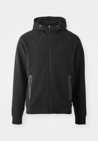 Schwarze Zip-Hoodie aus weichem Stoff, mit Kapuze, Raglanärmeln, zwei mit Reißverschluss versehenen Taschen und einem kleinen Logo auf der Brust.