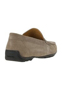 Scarpa slip-on in suede marrone con tomaia strutturata, costruzione morbida e suola in gomma nera con logo. Design liscio e sobrio.