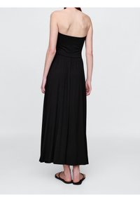 Svart strapless maxiklänning gjord av mjukt tyg, med en figurnära överdel och en flödande kjol som når anklarna.