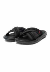 Sandalias negras con suela acolchada, que presentan tres correas cruzadas y un acento rojo. Fabricadas en material sintético suave para mayor comodidad.