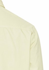 Koszula z krótkim rękawem w jasnym żółtym kolorze, wykonana z bawełny, z klasycznym kołnierzykiem, szwami na ramionach oraz subtelnym detalem haftu z tyłu.