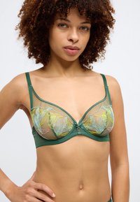 Zeleno nedrček z žico, ki ima prosojne mrežaste skodelice z rožnatim vezenjem v rumeni in roza barvi, okrasno sredinsko okovje in nastavljive naramnice.