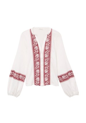 Witte blouse met lange, opgeblazen mouwen en een ronde halslijn. Voorzien van rode bloemenborduursels langs de voorkant en mouwen. Voorzien van knopen aan de voorkant.