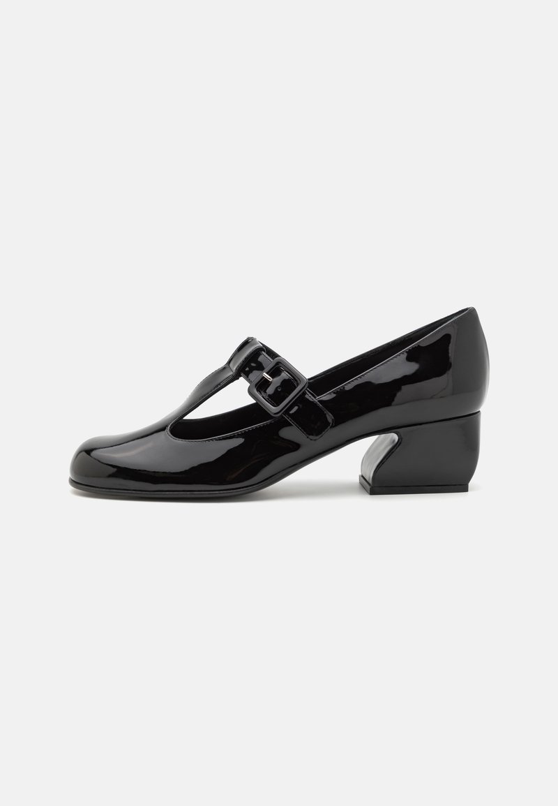 Zapatos de tacón T de charol negro con una hebilla cuadrada, puntera redondeada y un exclusivo tacón angular. Textura suave y acabado brillante.