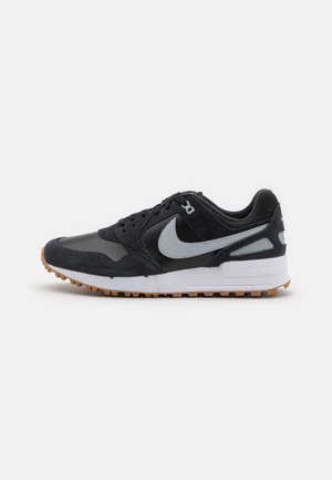 Ténis Nike com parte superior em camurça e pele preta, detalhes em cinza, entressola branca e sola em borracha de cones. Design clássico de sapatilha de corrida.
