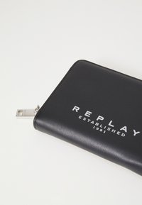 Black zippered wallet made of textured synthetic material with white "REPLAY ESTABLISHED 1981" lettering and silver hardware detail.
