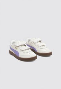 Zapatillas blancas con acentos morados, con un superior de cuero texturizado, punta redonda y correas de Velcro. Suela de goma marrón.