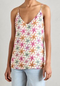 Top sin mangas con escote en V, confeccionado en una tela ligera, que presenta un patrón repetitivo de estrellas de mar en rosa, verde, naranja y púrpura sobre un fondo crema.