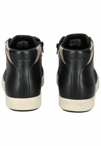 Černé kožené vysoké tenisky s síťovanými panely, béžovými akcenty a bílou gumovou podrážkou. Obsahují boční zipy pro snadný přístup.