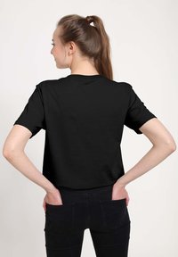 Sort kortærmet t-shirt lavet af blødt stof, med rund halsudskæring og en afslappet pasform. Ingen synlige mønstre eller accenter.