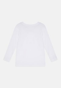 Chemise en coton blanc à manches longues avec un col arrondi, sans motifs ni accents et à la texture lisse. Vue arrière uniquement.