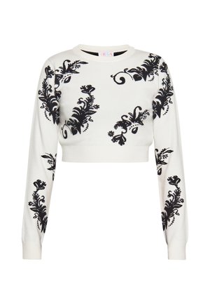 Weißer kurz geschnittener Pullover mit langen Ärmeln, der vorne, an den Ärmeln und Schultern schwarze Blumen- und Wirbelmuster zeigt.