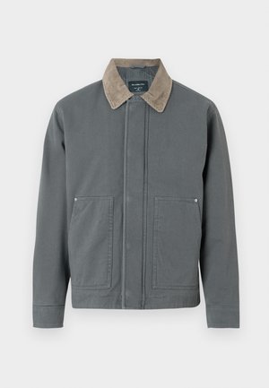 Pilkas drobės švarkas su šonkačių apykakle, dviem priekinėm kišenėm ir paprastu priekyje uždarymu. Yra tekstūruotas paviršius ir laisvas fasonas.