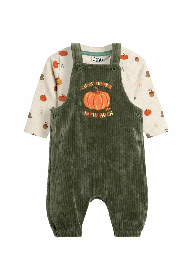 Grüne Corduroy-Latzhose mit verstellbaren Trägern und Kürbis-Graphic, kombiniert mit einem langärmeligen cremefarbenen Shirt mit herbstlichen Mustern.