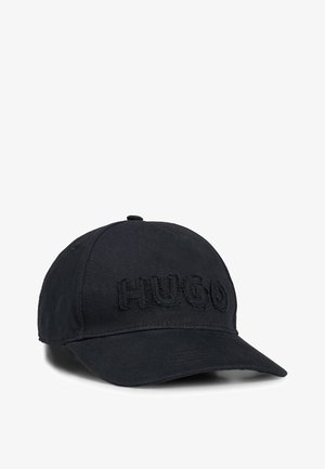 Black baseball cap made from fabric with an embroidered "HUGO" logo on the front. Features a curved brim and adjustable back strap.