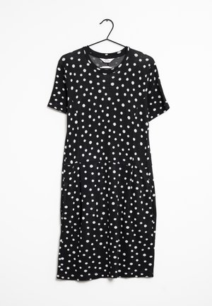 Schwarzes Kurzarmkleid mit weißen Punkten, Rundhalsausschnitt und lockerer Passform, an einem schwarzen Kleiderbügel vor weißem Hintergrund hängend.