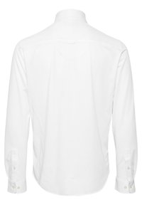 Chemise blanche à manches longues vue de dos avec poignets boutonnés et col classique sur un fond uni.