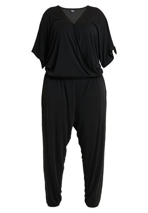 Combinaison noire en tissu doux et léger. Dotée d'un col en V, de manches courtes amples et d'une coupe décontractée avec des jambes fuselées.