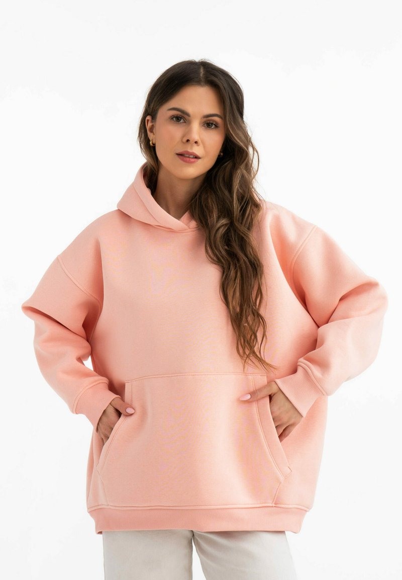 Felpa oversize rosa con tasca frontale, polsini a costine e cappuccio. Tessuto morbido con una superficie liscia. Silhouette semplice e rilassata.