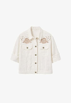 Giacca bianca corta con maniche arrotolate, chiusura frontale con bottoni, due tasche sul petto e ricamo floreale intagliato vicino alle spalle.