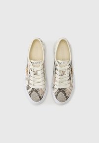 Baskets avec un motif peau de serpent en nuances de beige et gris, dotées d'une semelle en caoutchouc blanche et de lacets crème. Logo "GUESS" sur le côté.