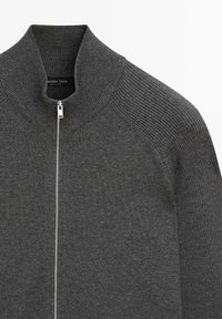 Dark gray knit sweater with full front silver zipper and ribbed high collar and shoulder detail.