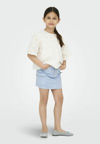 Witte eyelet top met gerimpelde mouwen, gecombineerd met een blauw gestreepte rok. Grijze platte schoenen maken de outfit af. Eenvoudig ontwerp en lichte kleuren.