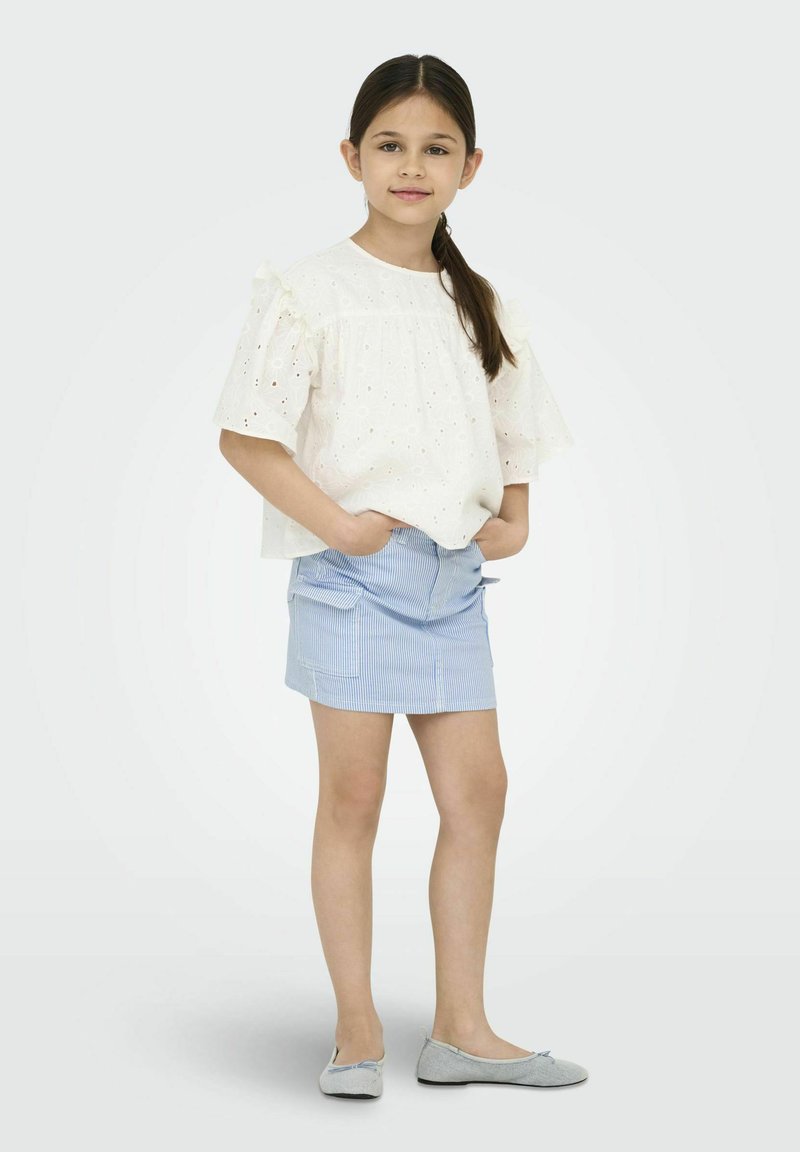 Witte eyelet top met gerimpelde mouwen, gecombineerd met een blauw gestreepte rok. Grijze platte schoenen maken de outfit af. Eenvoudig ontwerp en lichte kleuren.
