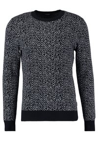 Sweter z dzianiny z wzorem zygzakowym w czerni i szarości, z okrągłym dekoltem oraz ściągaczami u rękawów i na dole. Wykonany z miękkiego, teksturowanego materiału.