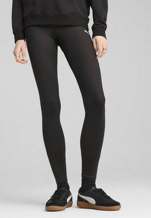 Black stretch leggings with a smooth texture and fitted design, featuring a small white logo on the side. Paired with black sneakers.