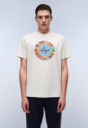 Beige katoenen t-shirt met een ronde graphic met blauwe ster, tekst en vlaggen. Ronde hals, korte mouwen, ontspannen pasvorm.