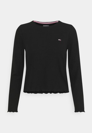 Sort langærmet ribstrikket skjorte med bølgede kanter og en lille rød, hvid og blå logo på øverste venstre bryst.