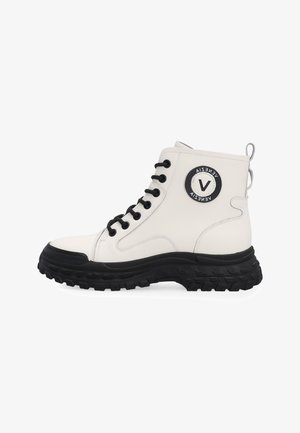 Bílé vysoké boty s černými šňůrkami, silnou robustní černou podrážkou a kulatým černo-bílým logem na kotníku.