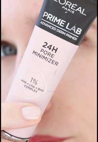 L'Oréal Paris Prime Lab Advanced Derm Primer in einer rosa Tube, beschriftet mit 24H Pore Minimizer, mit silbernen Akzenten und Details zu den aktiven Inhaltsstoffen.