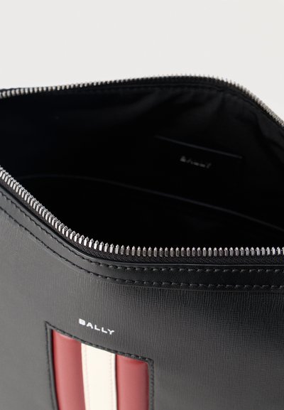 Μαύρο δερμάτινο πουγκί με ασημένιο φερμουάρ, με κόκκινες και λευκές κάθετες ρίγες και το λογότυπο της Bally στο μπροστινό μέρος.
