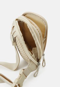 Nike Sportswear ESSENTIALS CROSSBODY UNISEX - Rankinė per petį - sanddrift/sail/baroque brown