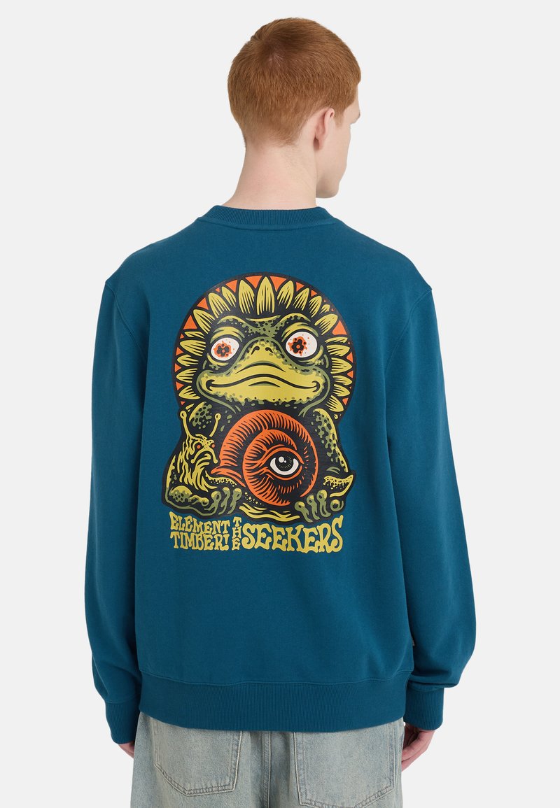 Φούτερ σε χρώμα τυρκουάζ με μεγάλο, πολύχρωμο γραφικό σχεδιασμό βάτραχου και σαλιγκαριού, με παιχνιδιάρικα μάτια και ηλιακά στοιχεία στην πλάτη.