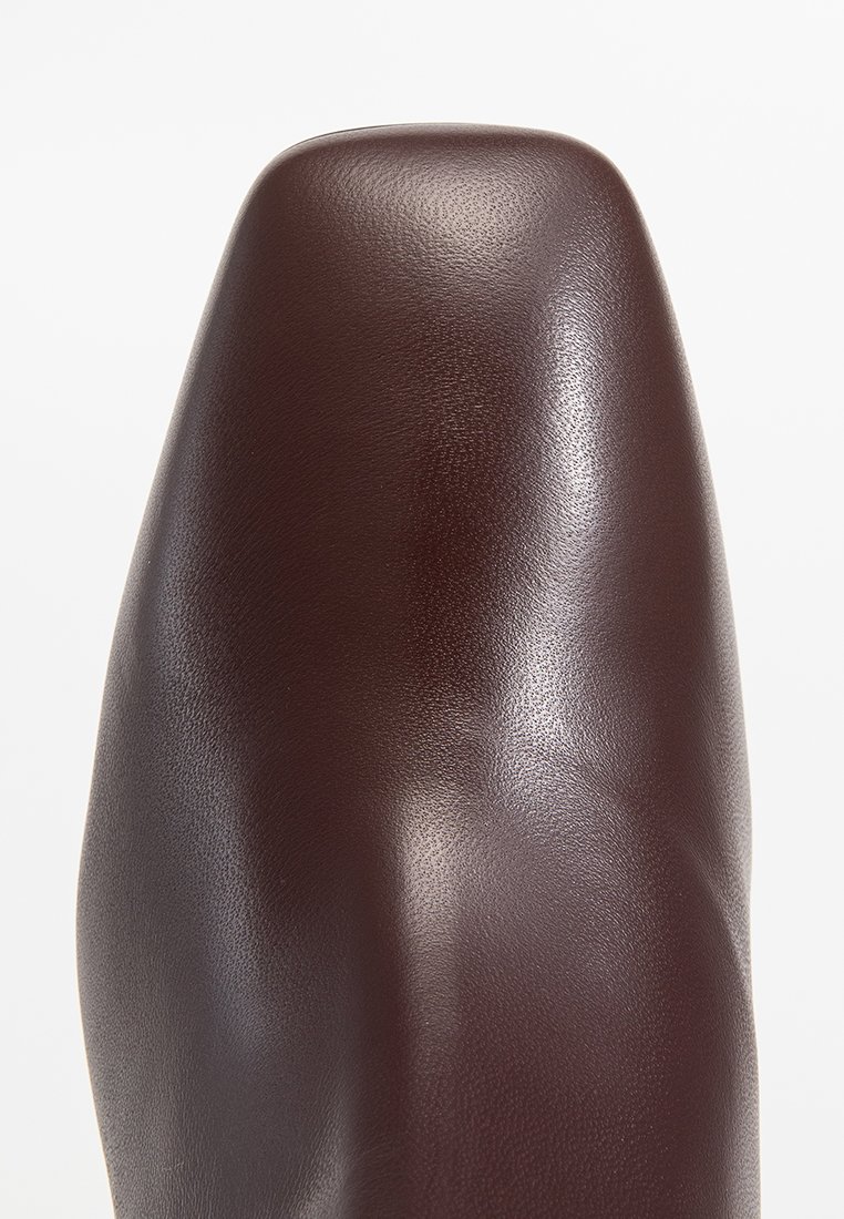 Bordowe skórzane buty o gładkim, błyszczącym wykończeniu. Posiadają okrągły czubek i nowoczesny design. Brak widocznych ozdób lub elementów metalowych.