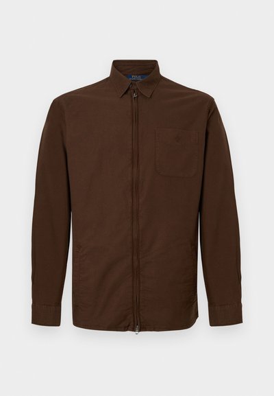 Casaco castanho de zíper feito de algodão, com gola, mangas longas e um bolso no peito com um logo bordado.