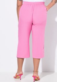 Roze cropped broeken met een elastische tailleband, met een gladde textuur en een rechte pasvorm, gecombineerd met felle roze hoge hakken.