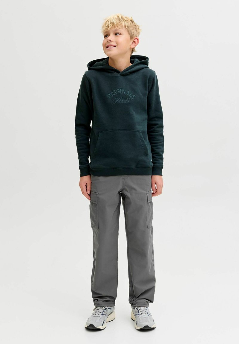 Tamnozeleni dukserica s prednjim kenguruzim džepom i utisnutim tekstom "Originals", u kombinaciji sa sivim cargo hlačama koje imaju bočne džepove.