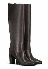 Bottines en cuir marron hauteur genou avec un bout carré et un talon bloc. Texture lisse avec des accents de couture et une silhouette ajustée.
