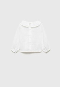 Blusa bianca a maniche lunghe realizzata in tessuto leggero. Caratterizzata da un colletto rotondo, chiusura con bottoni sulla parte posteriore e polsini elasticizzati.