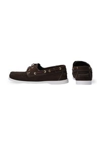 Braune Wildleder-Bootsschuhe mit weißen Gummisohlen, goldenen Ösen, dekorativen Nähten und klassischem Schlupfdesign.