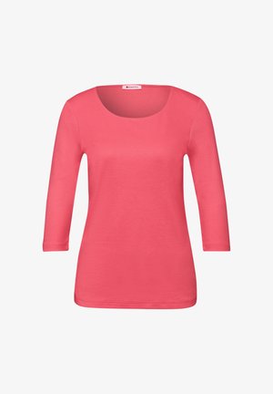 Corail, haut à manches trois-quarts avec un col rond. Confectionné dans un tissu doux et extensible. Texture lisse sans motifs ni accents visibles.