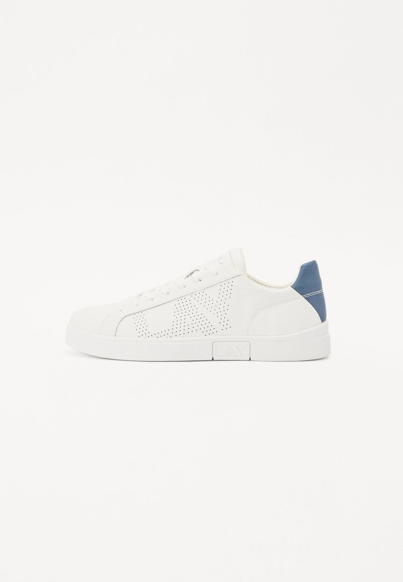 Fehér sneaker sima bőrből, perforált mintázattal az oldalon, tengerészkék akcentussal a saroknál, és fehér gumitalppal. Fűzővel együtt.