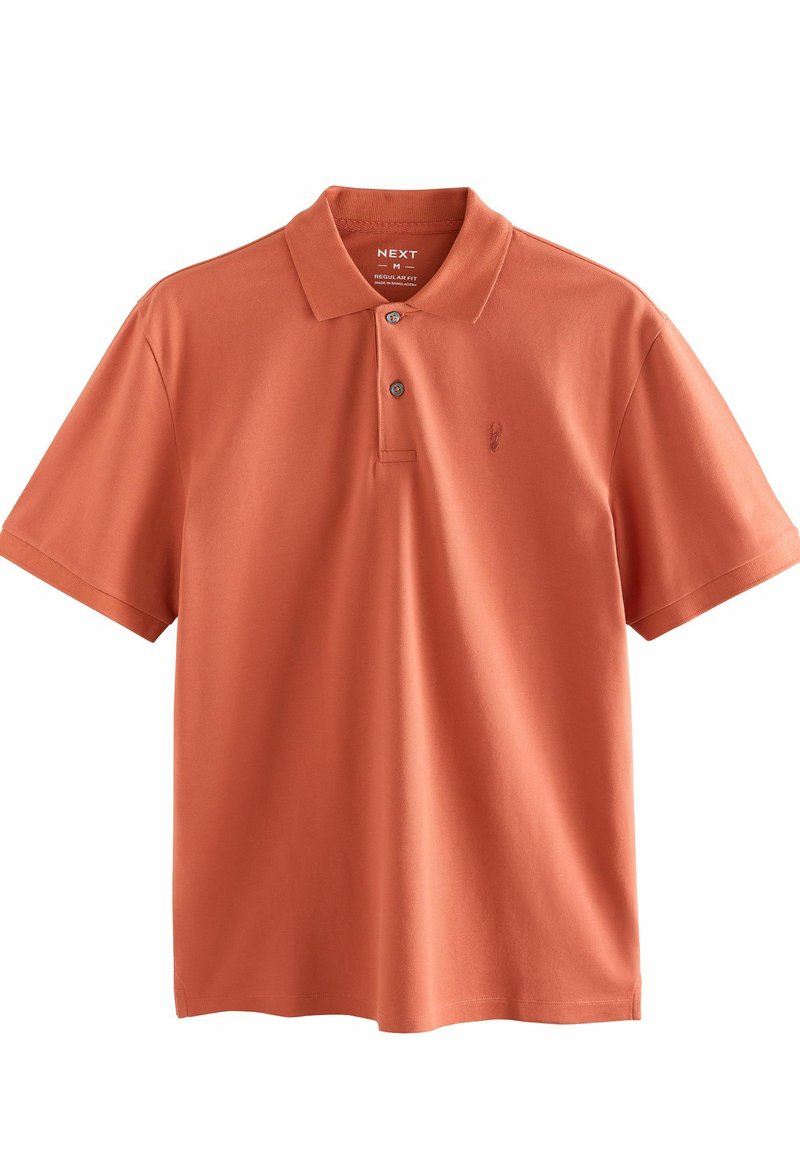 Polo naranja de algodón, con cuello de camisa, tapeta de tres botones y un pequeño logo en el lado izquierdo del pecho. Corte regular.