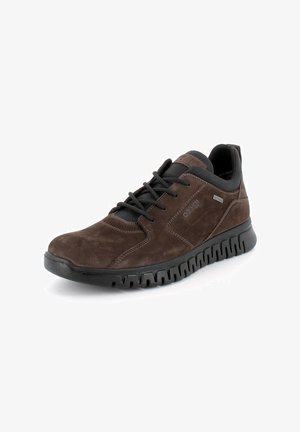 Sneaker in suede marrone con accenti neri, design con lacci, collo imbottito e suola in gomma testurizzata con un motivo ondulato.