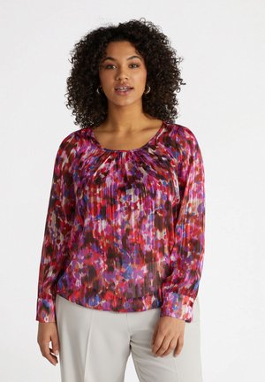 Blusa multicolore a maniche lunghe con scollo rotondo, caratterizzata da un design plissettato in tonalità di rosso, rosa e viola con una texture trasparente.